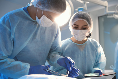 Photo of Team of professional doctors performing operation in surgery room