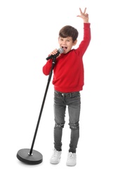 Photo of Cute little boy singing into microphone on white background