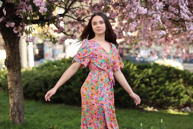 Beautiful woman near blossoming tree on spring day