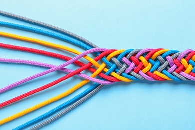 Photo of Braided ropes on color background, top view. Unity concept