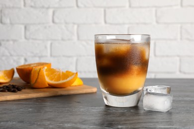 Photo of Tasty refreshing drink with coffee and orange juice on grey marble table, space for text