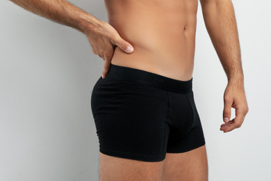 Man in black underwear on white background, closeup