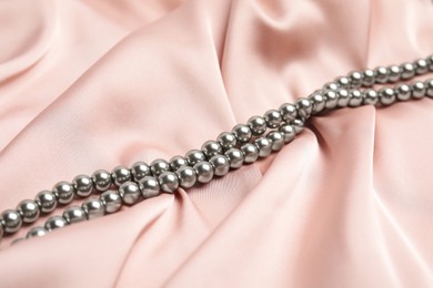 Photo of Beautiful silver pearls on delicate pink silk