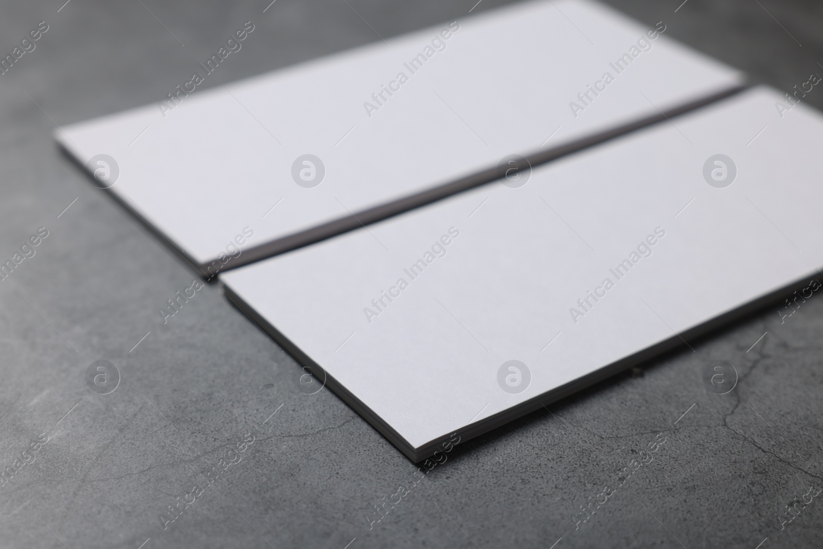 Photo of Blank business cards on grey textured table, closeup. Mockup for design