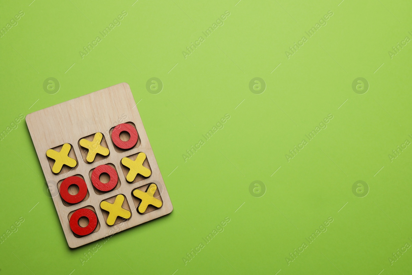 Photo of Tic tac toe set on light green background, top view. Space for text