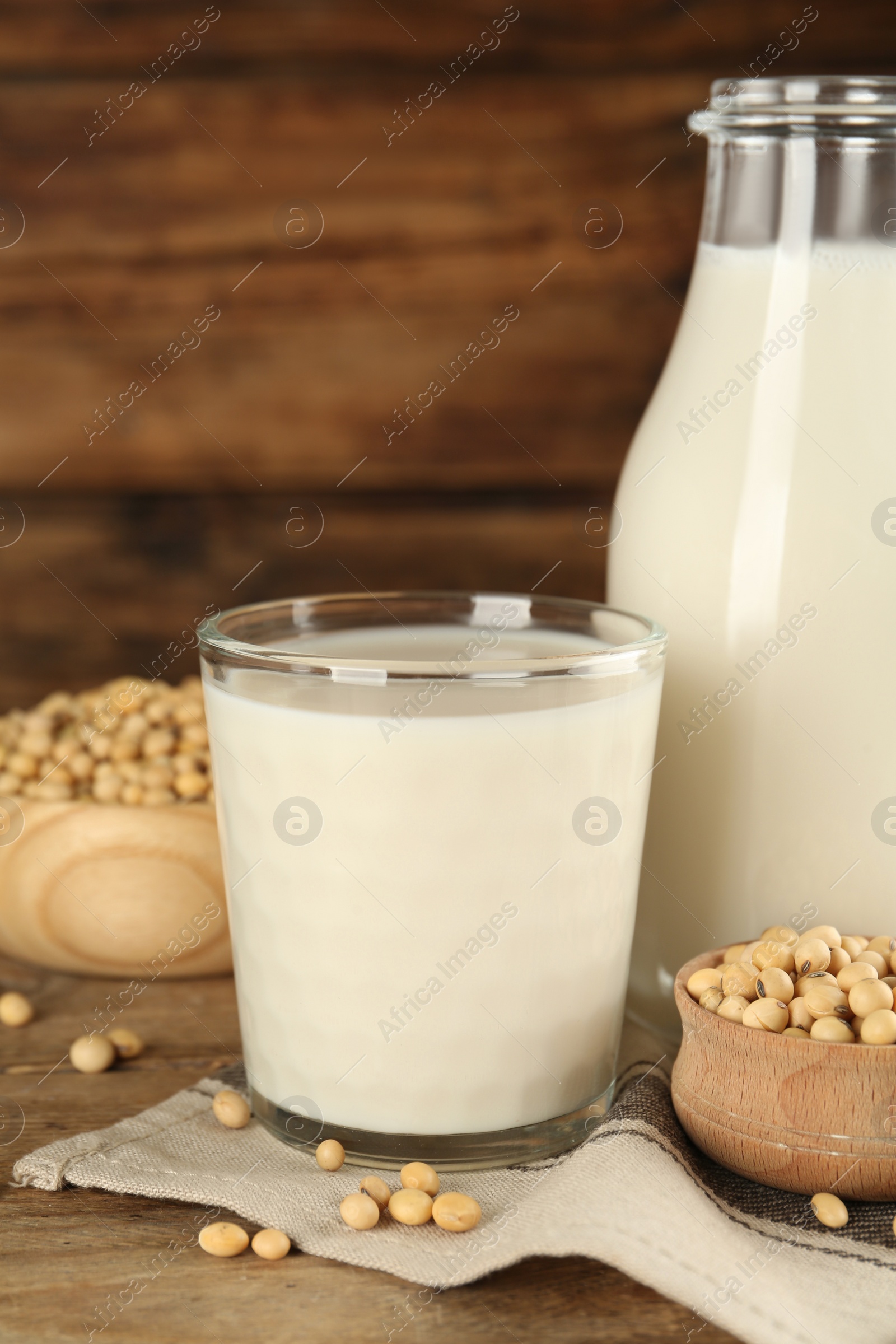 Photo of Fresh soy milk and grains on wooden table