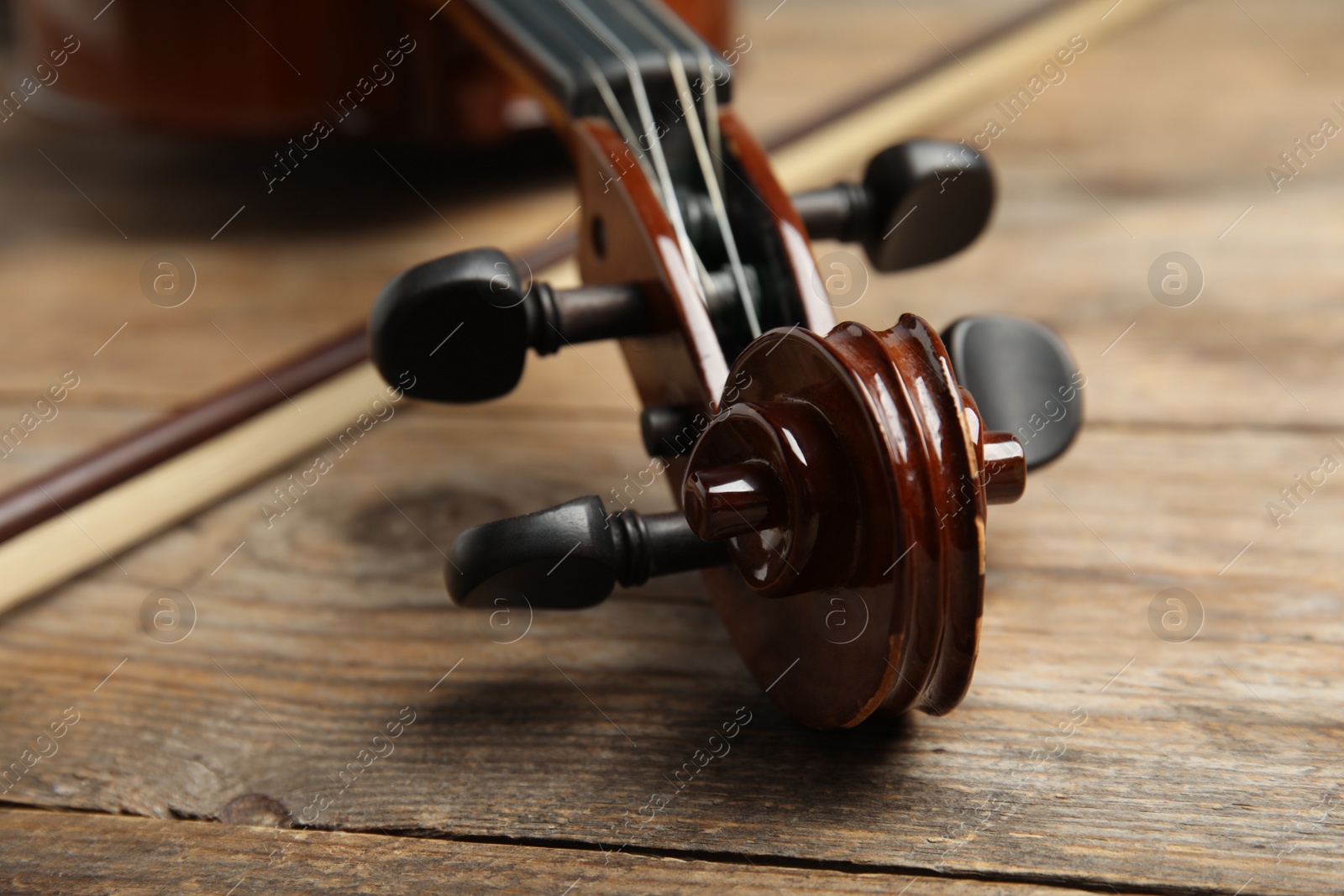 Photo of Beautiful violin and bow on wooden table, closeup