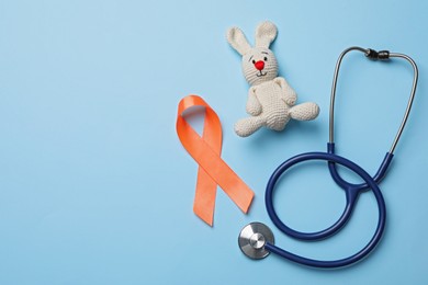 Orange ribbon, toy bunny and stethoscope on light blue background, flat lay with space for text. Multiple sclerosis awareness