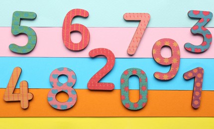 Wooden numbers on colorful background, flat lay