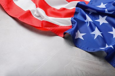 Photo of American flag on light grey background, closeup. Space for text