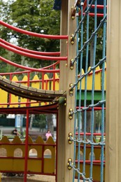 Photo of Children's playground with climbing rope net on summer day
