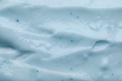 Photo of Closeup view of light blue body cream as background