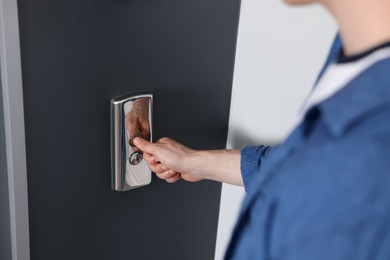 Photo of Man pressing elevator call button, closeup view