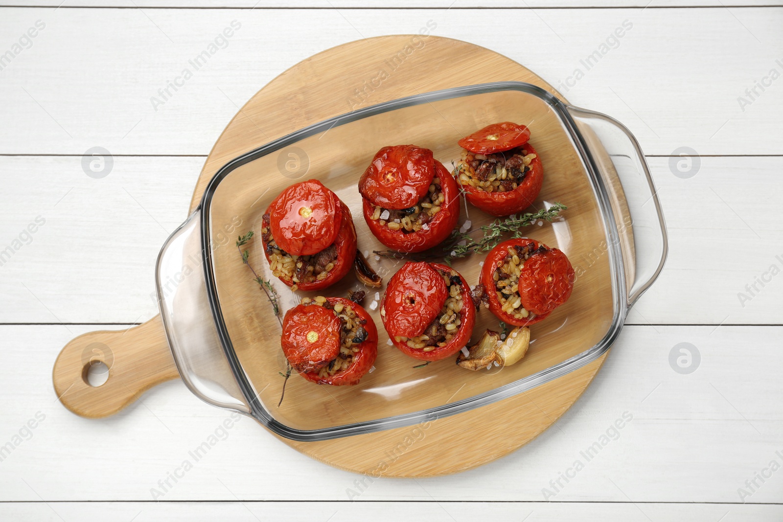 Photo of Delicious stuffed tomatoes with minced beef, bulgur and mushrooms on white wooden table, top view