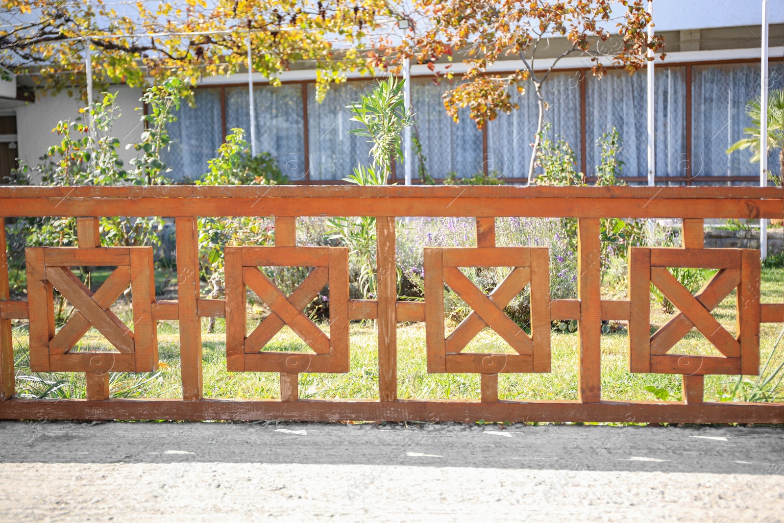 Photo of Beautiful wooden fence near green lawn on sunny day outdoors