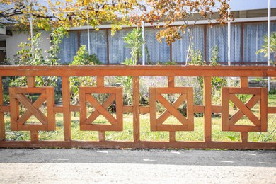 Photo of Beautiful wooden fence near green lawn on sunny day outdoors