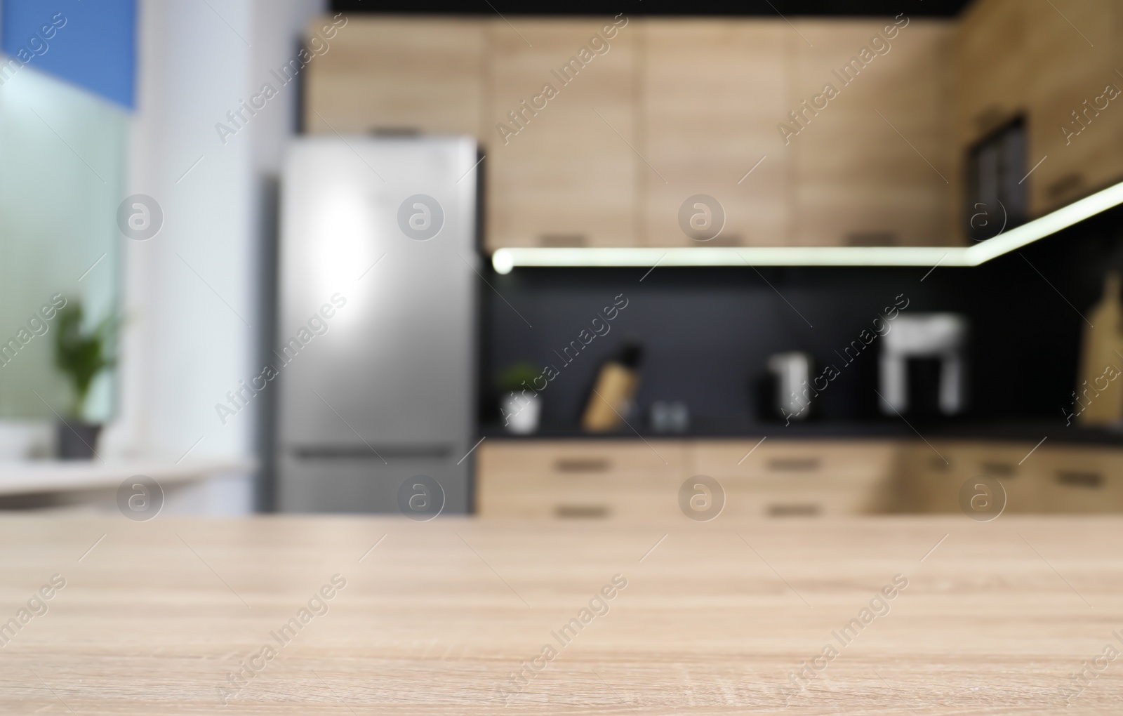 Photo of Countertop and blurred view of cozy modern kitchen interior on background