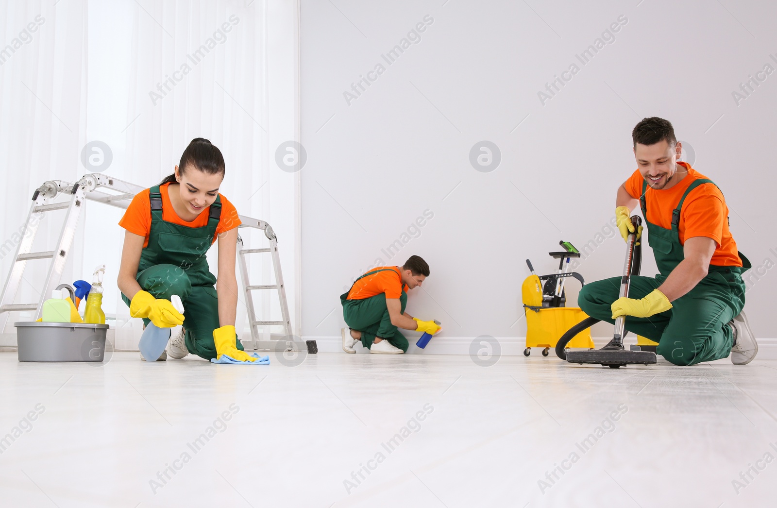 Photo of Team of professional janitors cleaning room after renovation