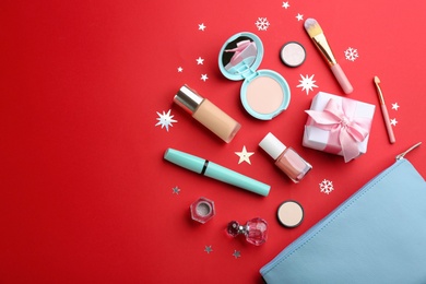 Photo of Flat lay composition with decorative cosmetic products on red background. Winter care