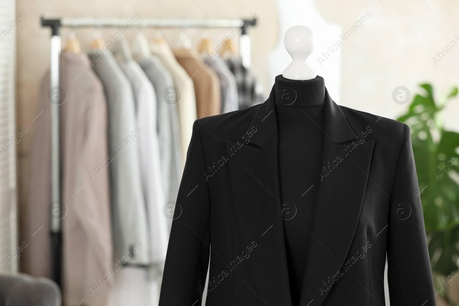 Photo of Mannequin with black jacket in tailor shop, space for text