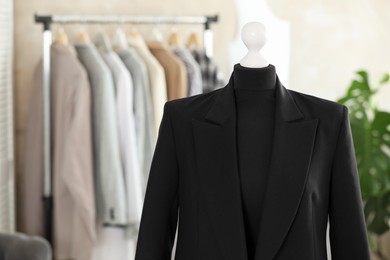 Photo of Mannequin with black jacket in tailor shop, space for text