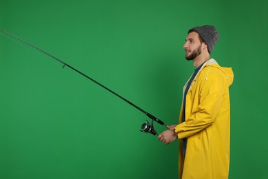 Fisherman with fishing rod on green background