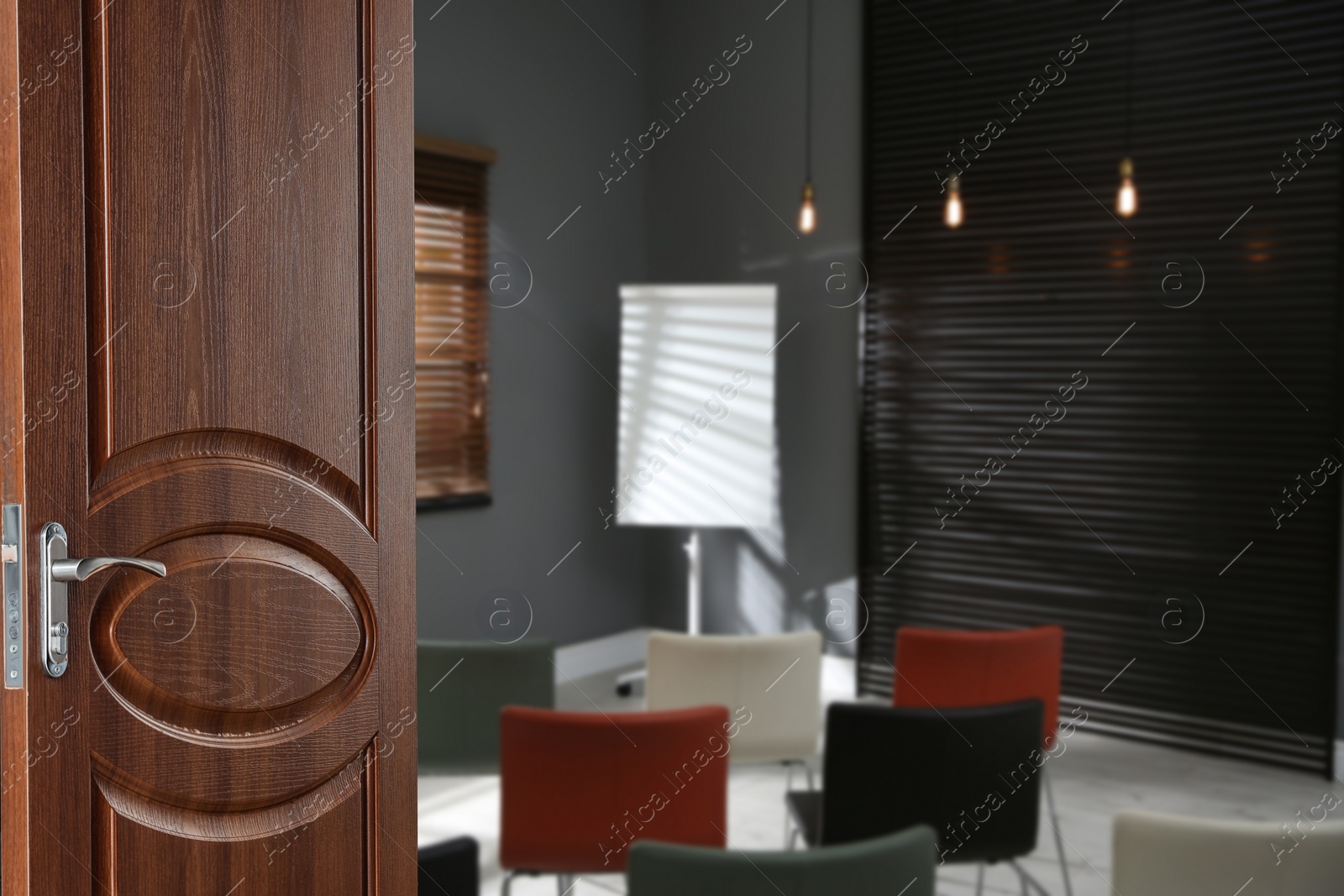 Image of Wooden door open into modern empty classroom