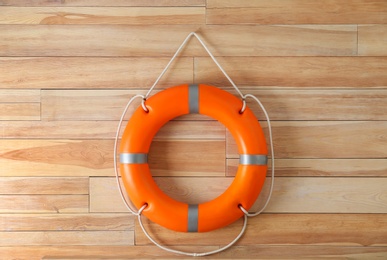 Photo of Orange lifebuoy on wooden background. Rescue equipment
