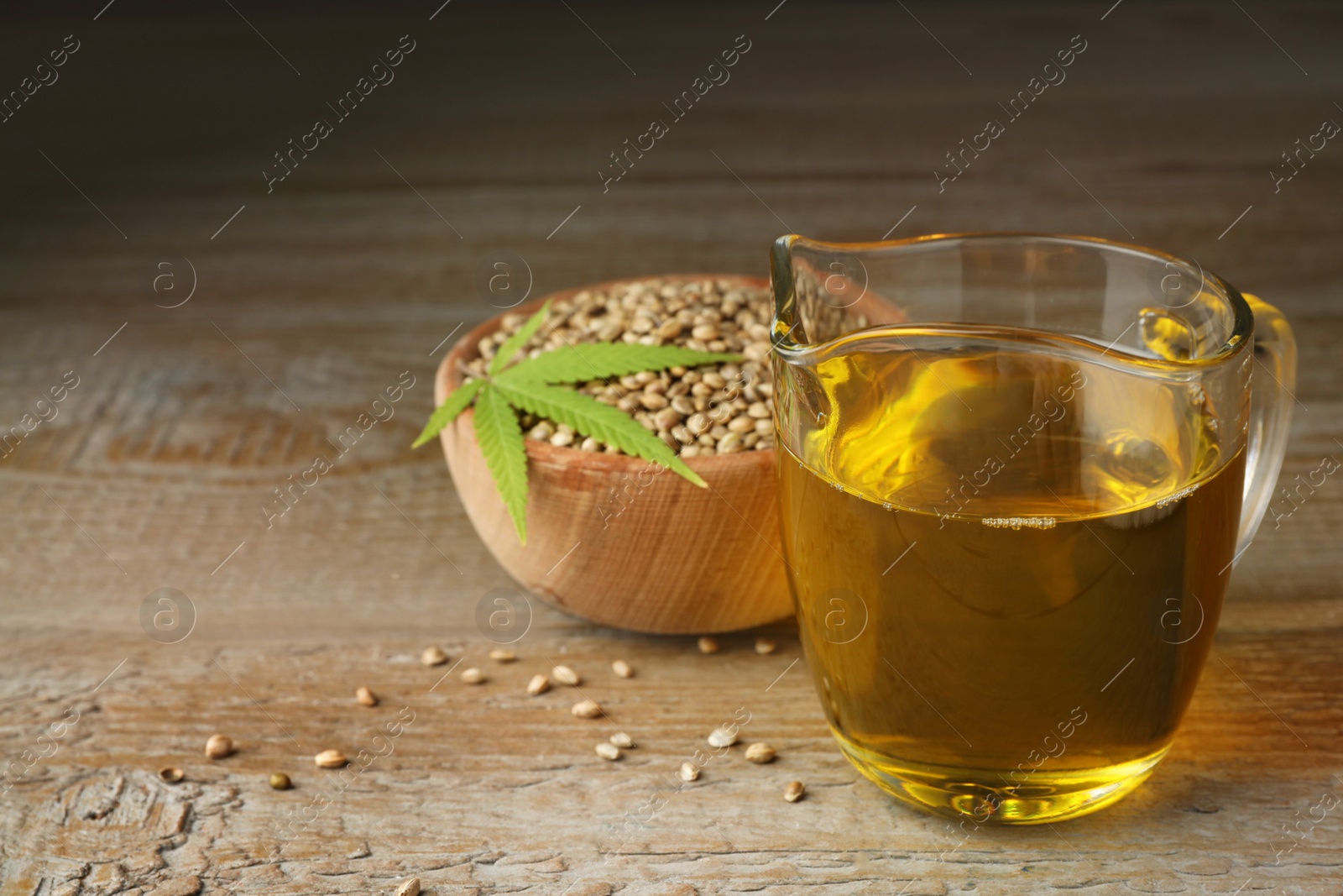 Photo of Composition with hemp oil on wooden table