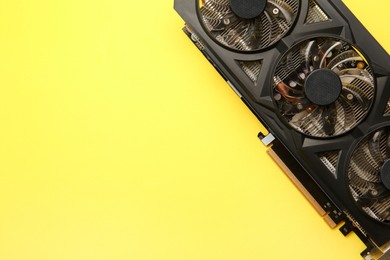 Photo of One graphics card on yellow background, top view. Space for text