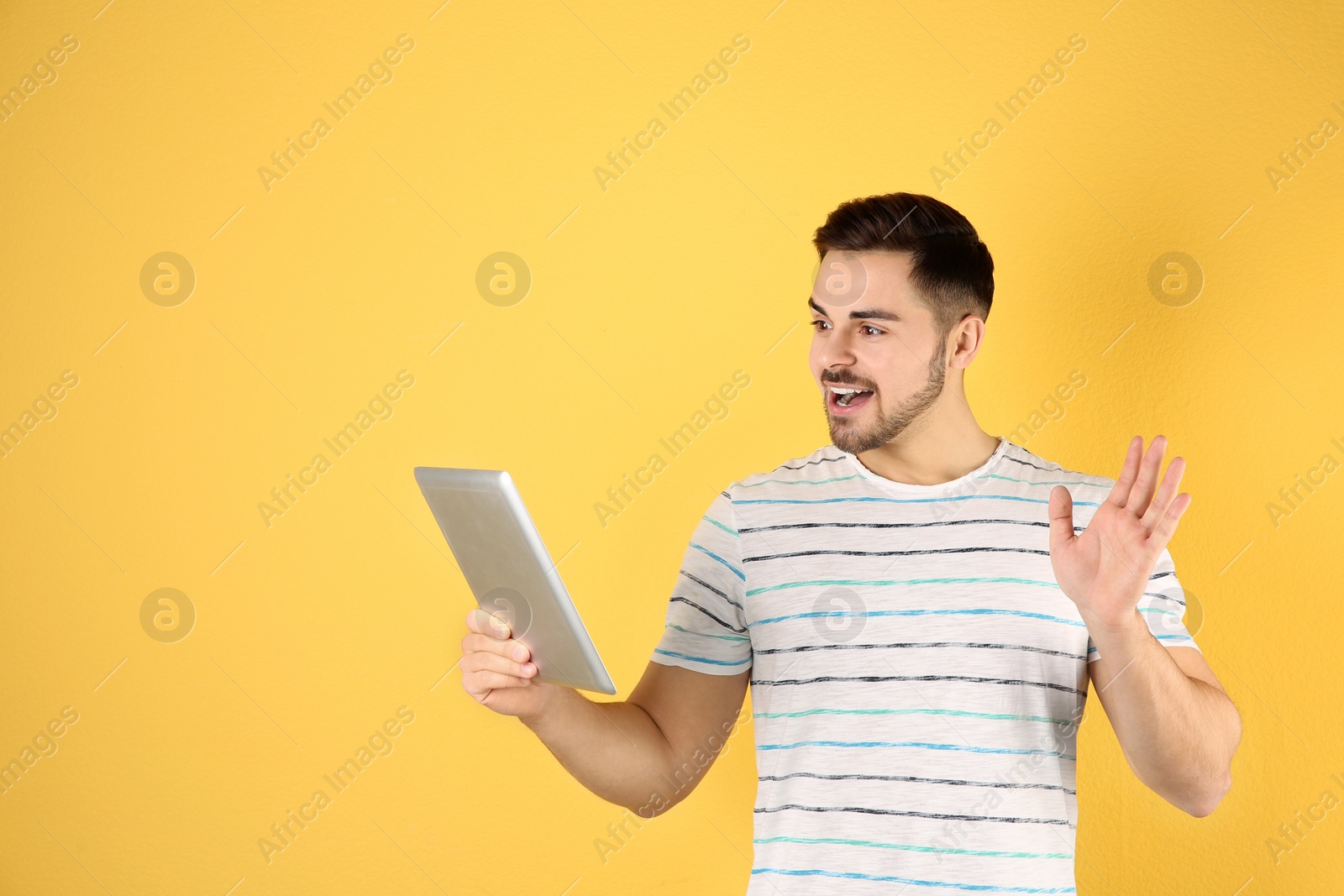 Photo of Man using tablet for video chat on color background. Space for text