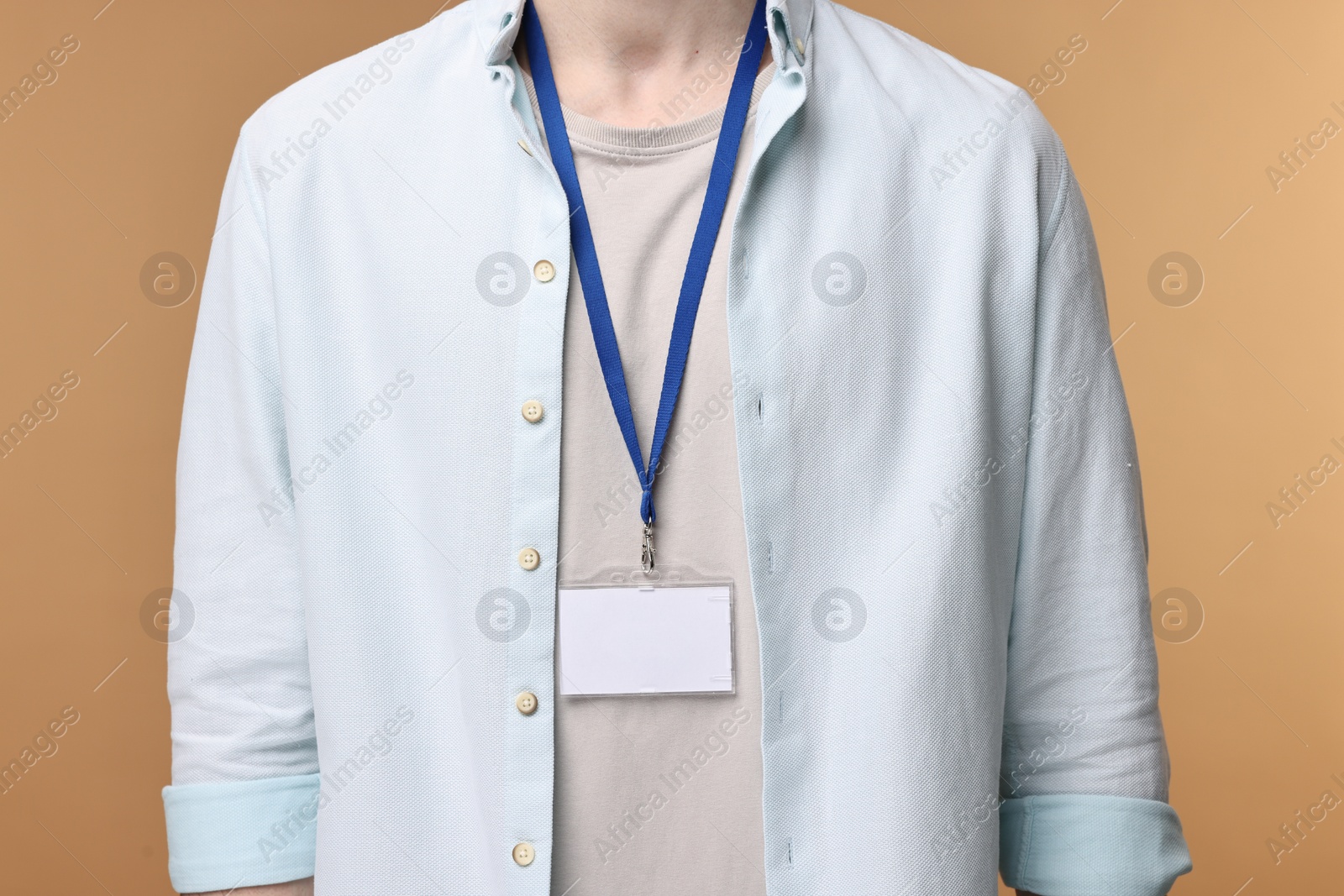 Photo of Man with empty badge on beige background, closeup