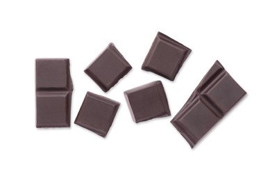 Pieces of delicious dark chocolate bar on white background, top view