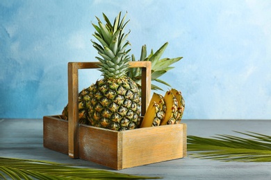 Photo of Fresh pineapples in box on table