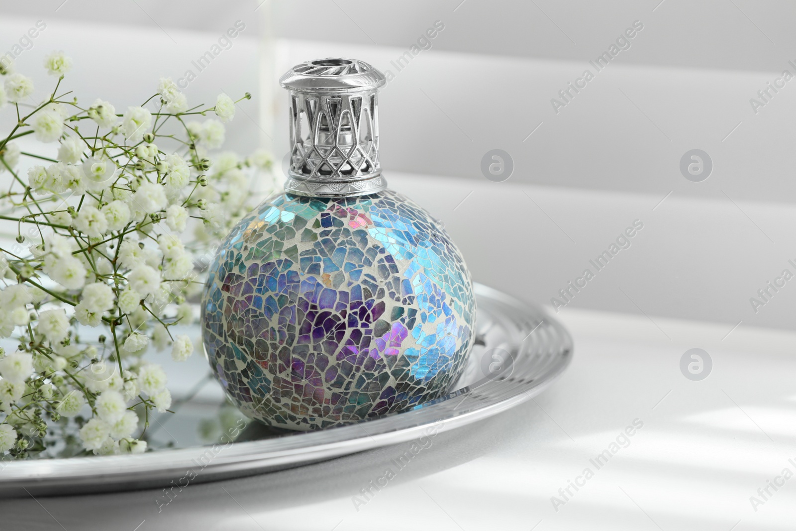 Photo of Beautiful catalytic purifying lamp and flowers on window sill, space for text. Interior element