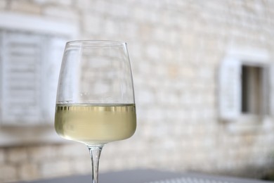 Photo of Glass of wine outdoors, closeup. Space for text