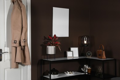 Photo of Stylish hallway interior with empty canvas on brown wall. Mockup for design