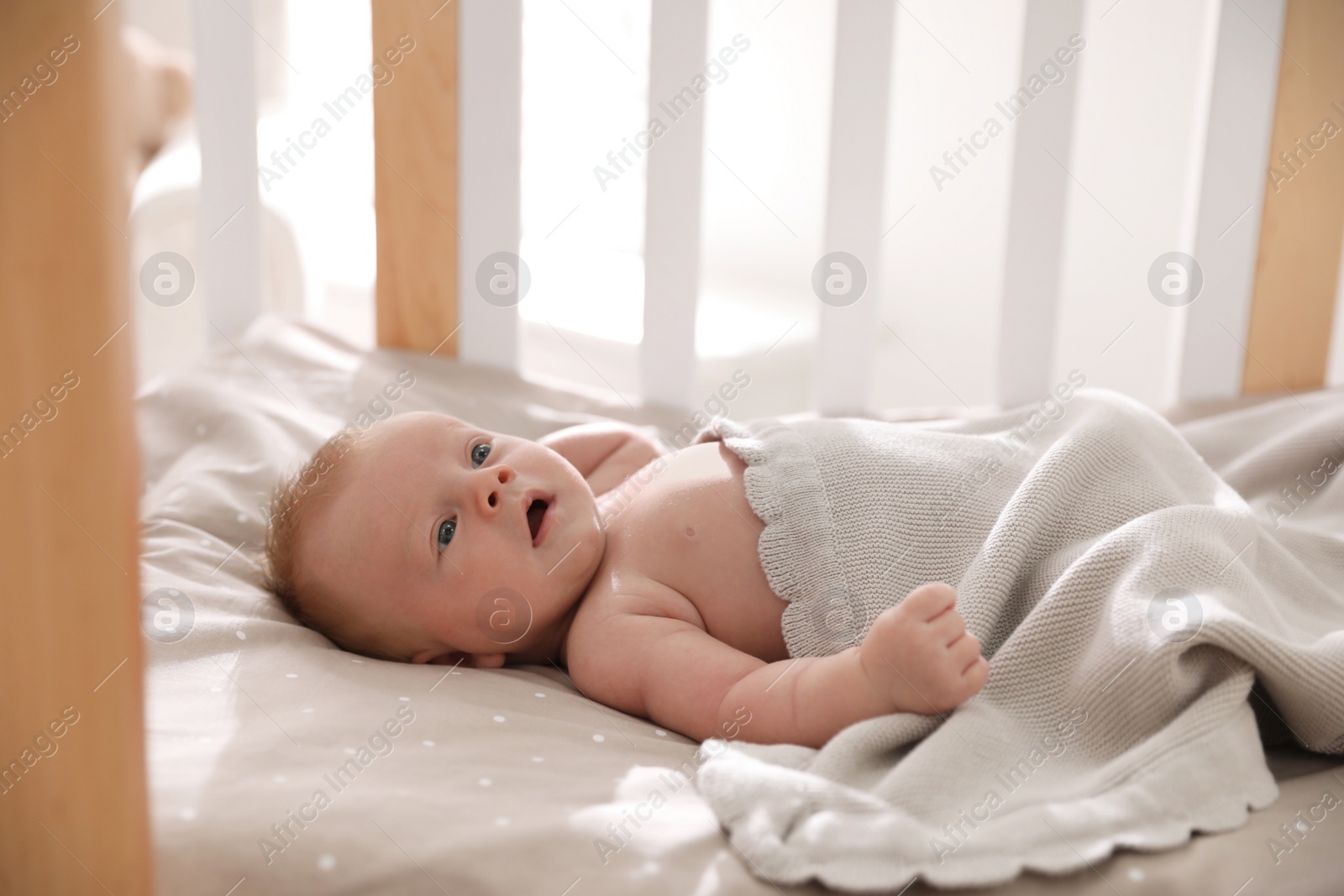 Photo of Cute little child lying in cot. Healthy baby