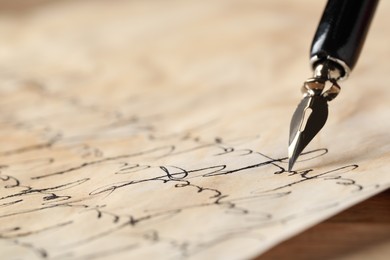 Photo of Writing with fountain pen on vintage parchment at table, closeup. Space for text