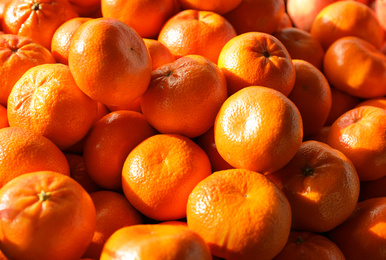 Photo of Juicy fresh ripe tangerines, closeup. Wholesale market