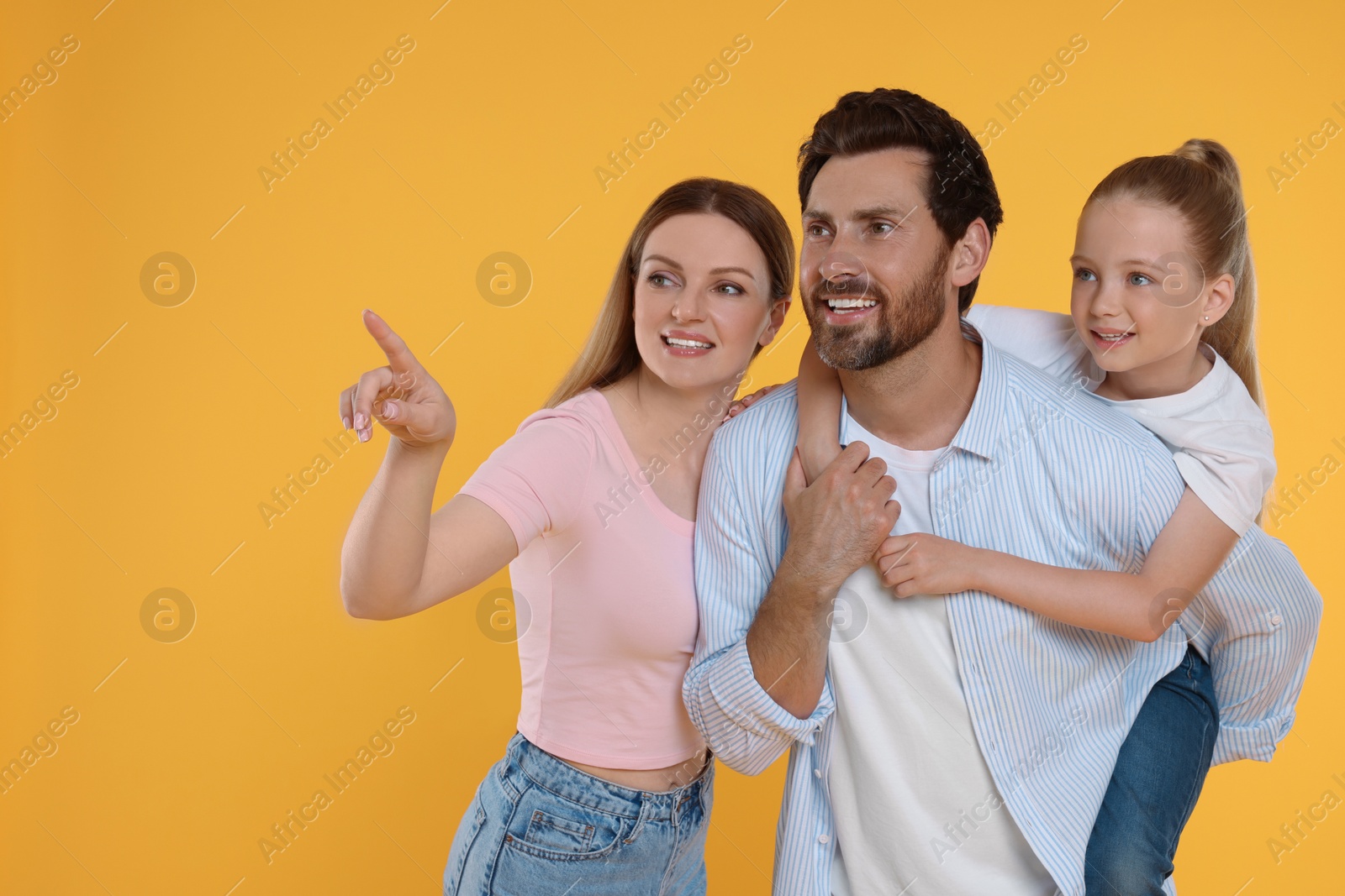 Photo of Happy family on orange background, space for text