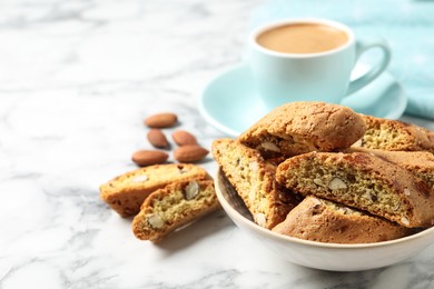 Tasty cantucci and cup of aromatic coffee on white marble table, space for text. Traditional Italian almond biscuits