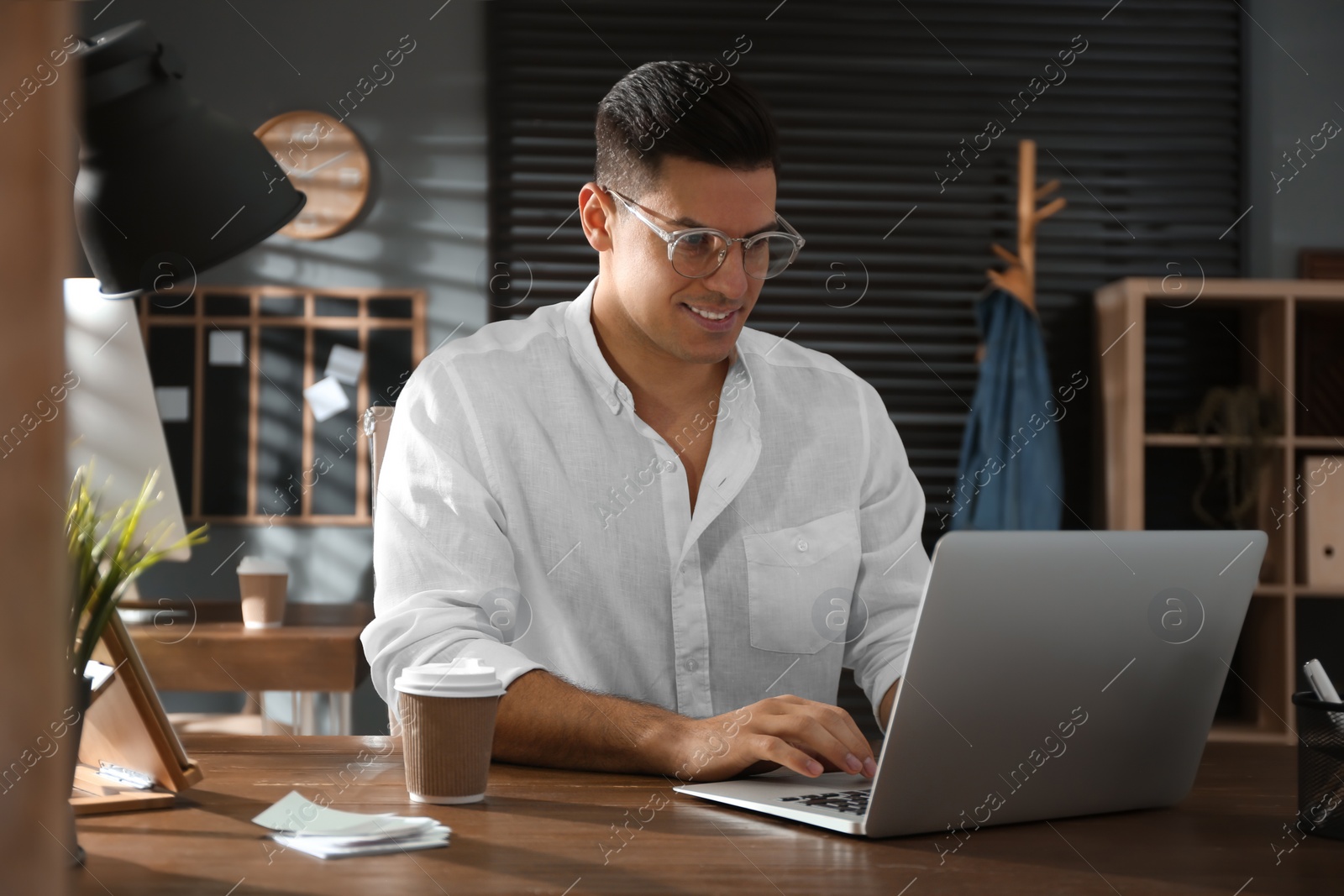 Photo of Freelancer working on laptop at table indoors