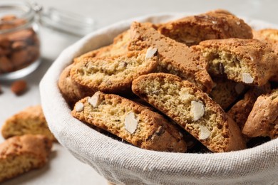 Photo of Traditional Italian almond biscuits (Cantucci) in basket on table, closeup