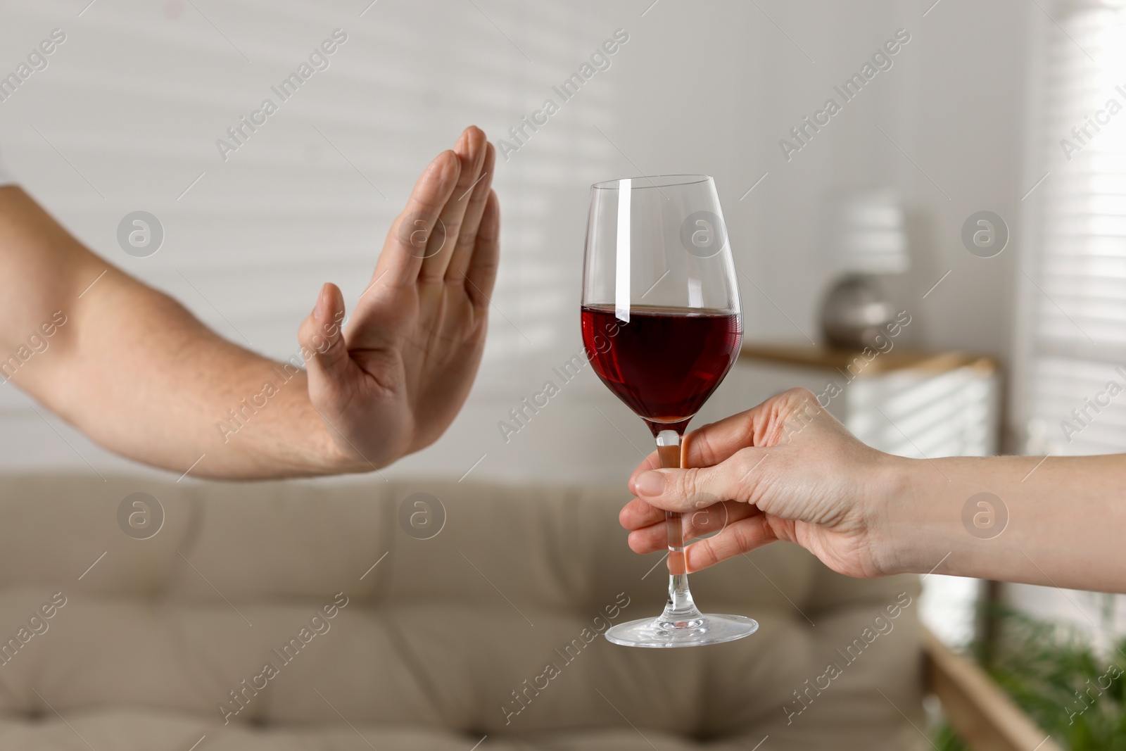 Photo of Man refusing to drink red wine indoors, closeup. Alcohol addiction