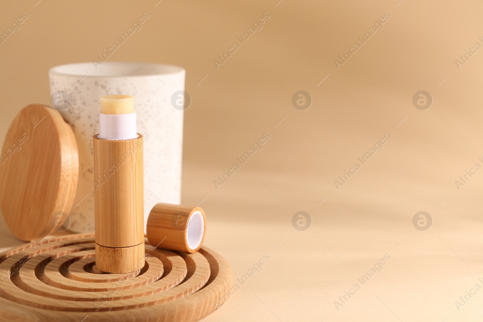 Photo of Lip balm on beige background, space for text