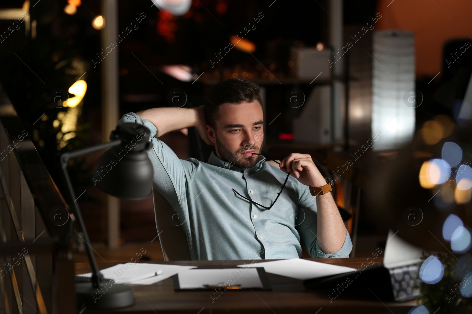 Photo of Young man working in office at night