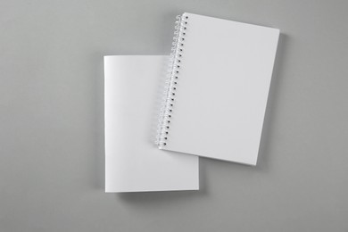 Photo of Blank brochure and notebook on grey background, flat lay. Mockup for design