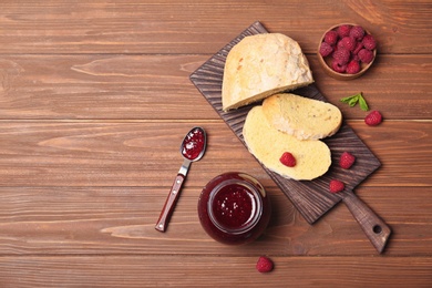 Photo of Beautiful composition with delicious raspberry jam on wooden table, top view