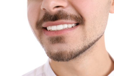 Photo of Young man with healthy teeth smiling on white background, closeup